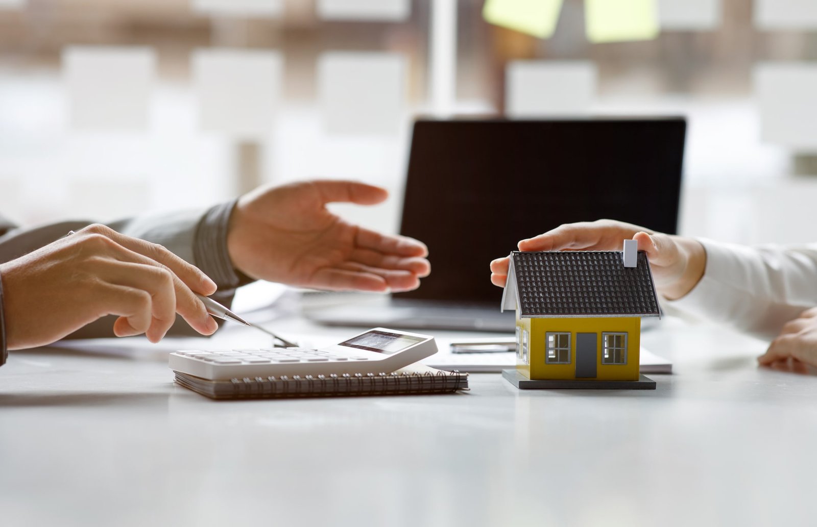 small house on keychain laying beside calculator